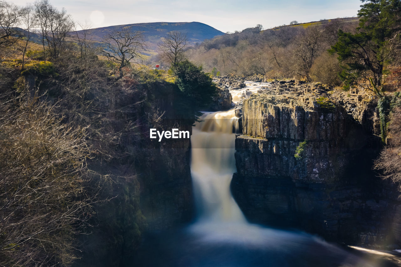 View of waterfall with mountain in background