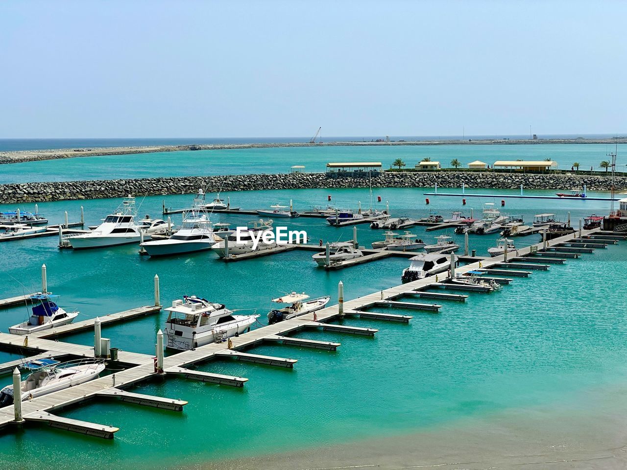 water, sea, marina, dock, nautical vessel, sky, nature, land, transportation, beach, bay, no people, coast, day, blue, clear sky, scenics - nature, beauty in nature, horizon over water, pier, vacation, ocean, moored, shore, port, tranquility, horizon, travel destinations, tranquil scene, mode of transportation, harbor, travel, turquoise colored, outdoors, vehicle, body of water, in a row, idyllic, sunny, high angle view, architecture, sunlight