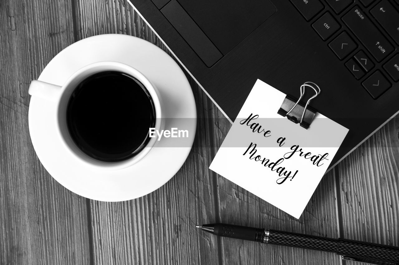 communication, black and white, table, coffee, mug, cup, coffee cup, wood, drink, text, monochrome, food and drink, monochrome photography, font, wireless technology, black, indoors, computer, technology, high angle view, paper, white, business, directly above, refreshment, no people, laptop, still life, black coffee, western script