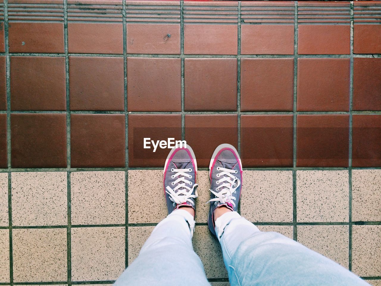 Low section of woman standing on tiled floor