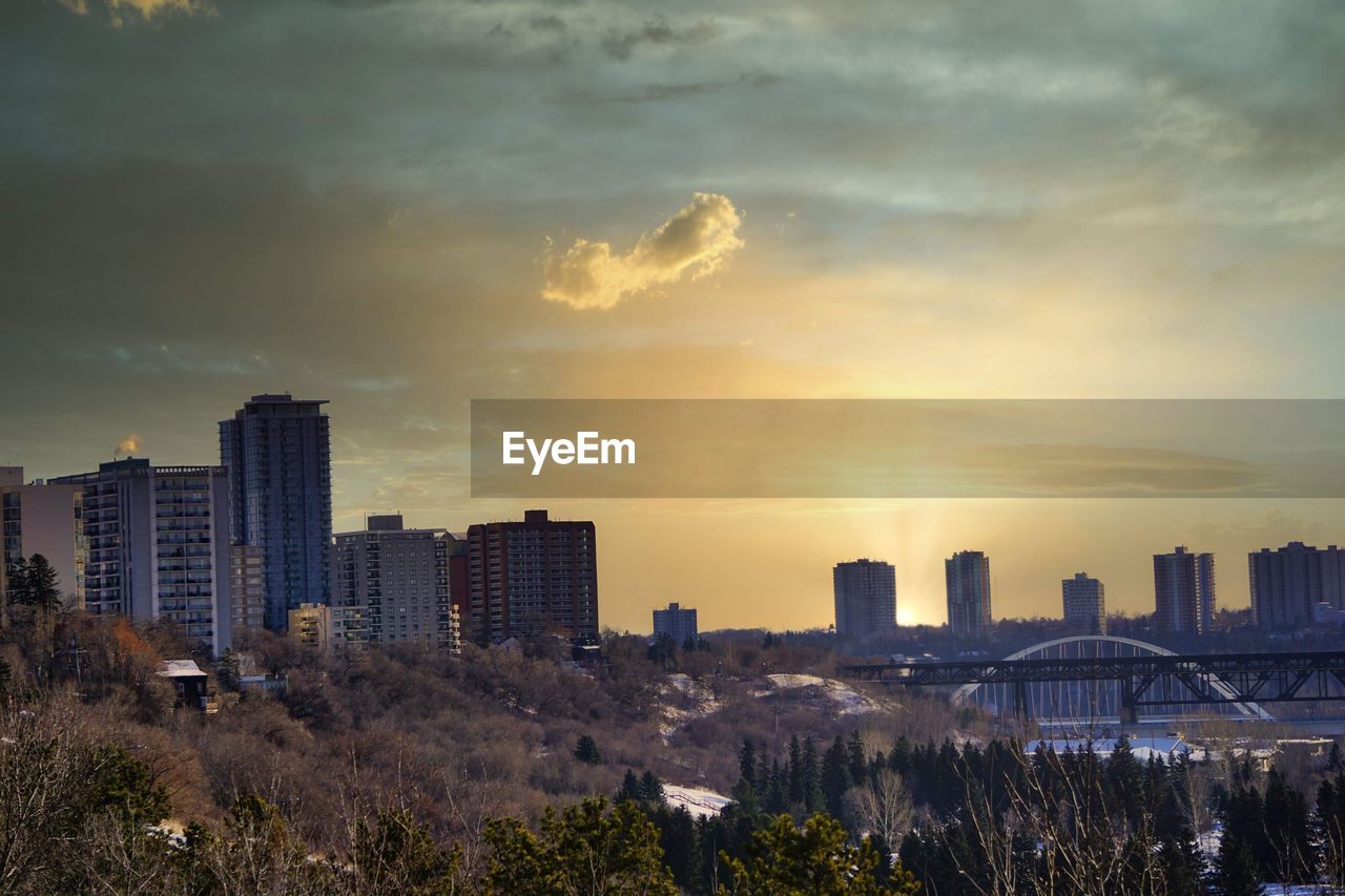 Buildings in city against sky during sunset