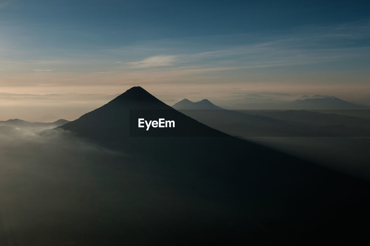 Scenic view of mountains during foggy weather against sky
