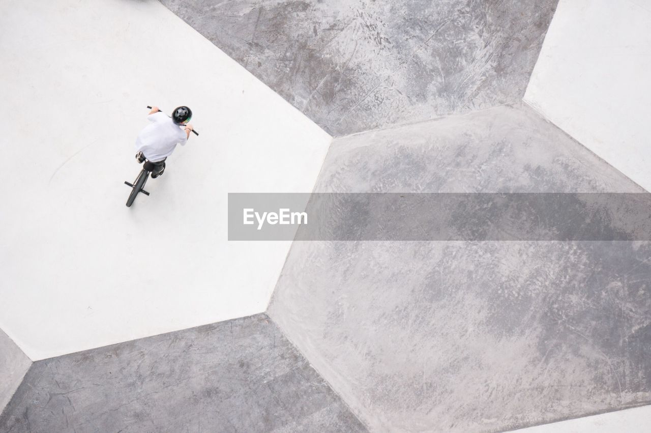 Directly above shot of person riding bmx cycling at skateboard park