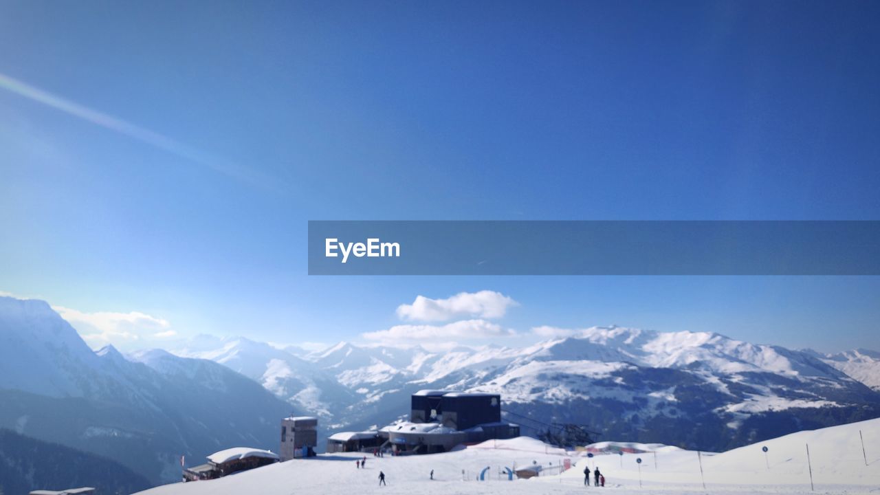 Scenic view of snowcapped mountains against blue sky