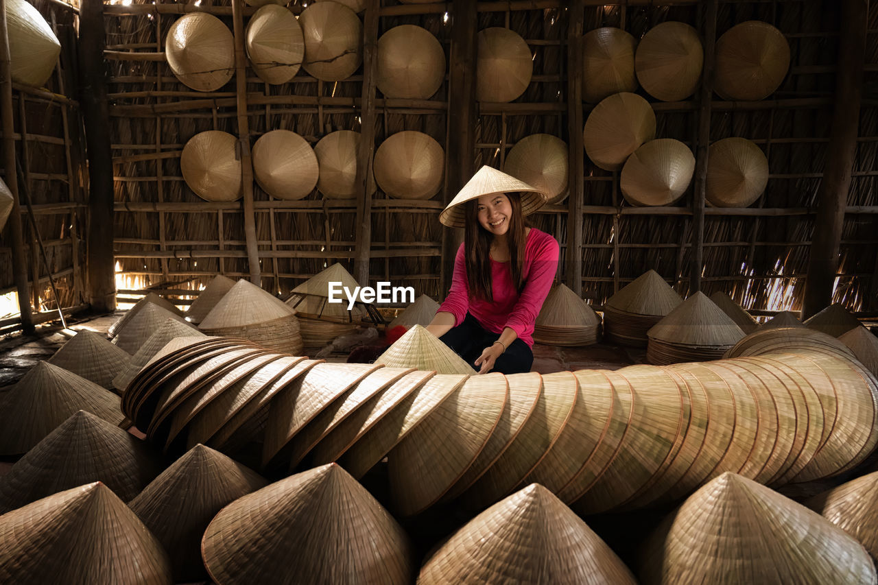 Asian traveler female craftsman making the traditional vietnam hat 