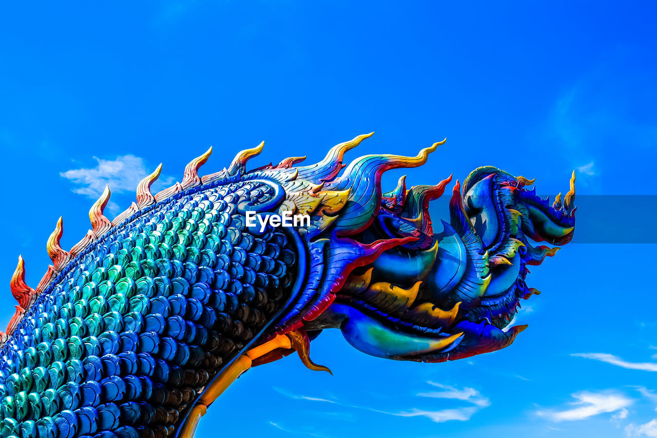 LOW ANGLE VIEW OF STATUE OF DRAGON AGAINST BLUE SKY