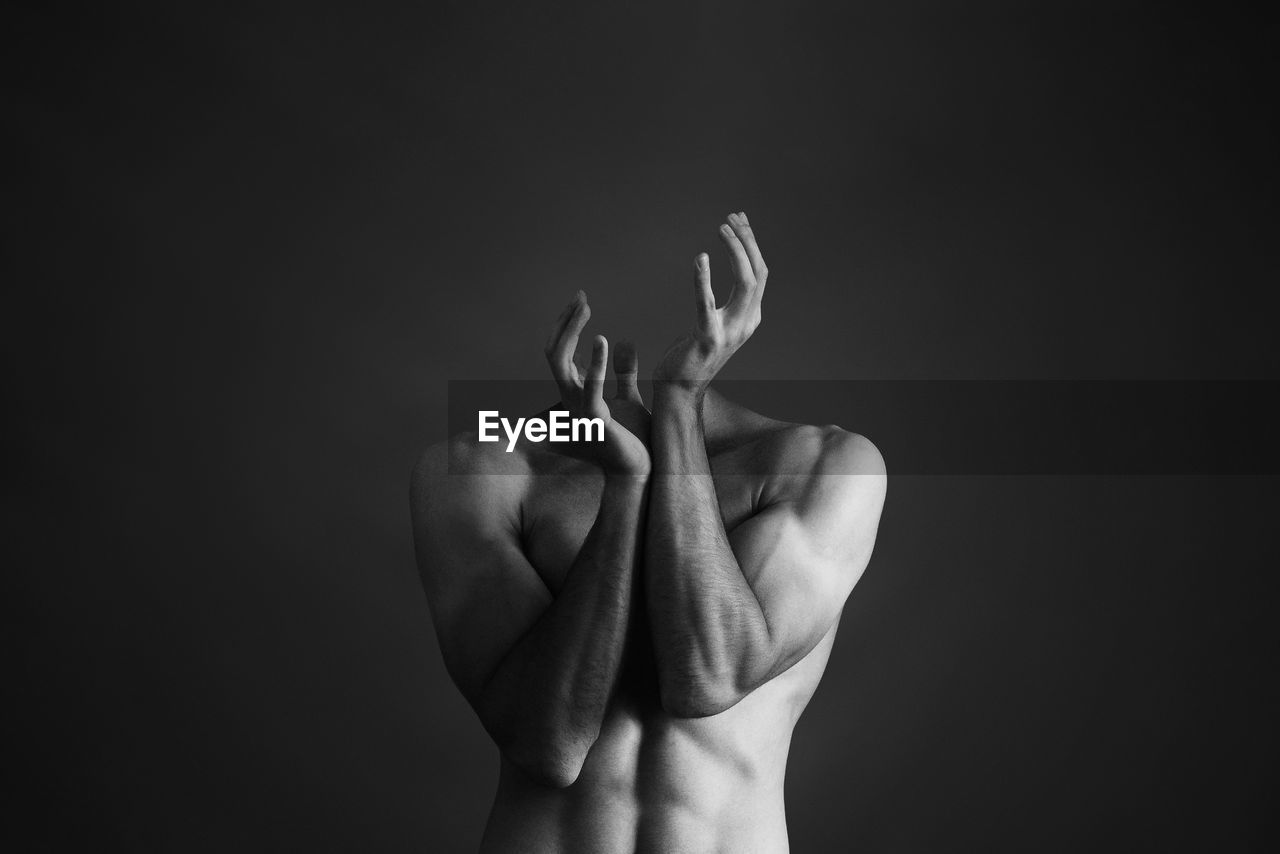 Decapitated shirtless man against gray background