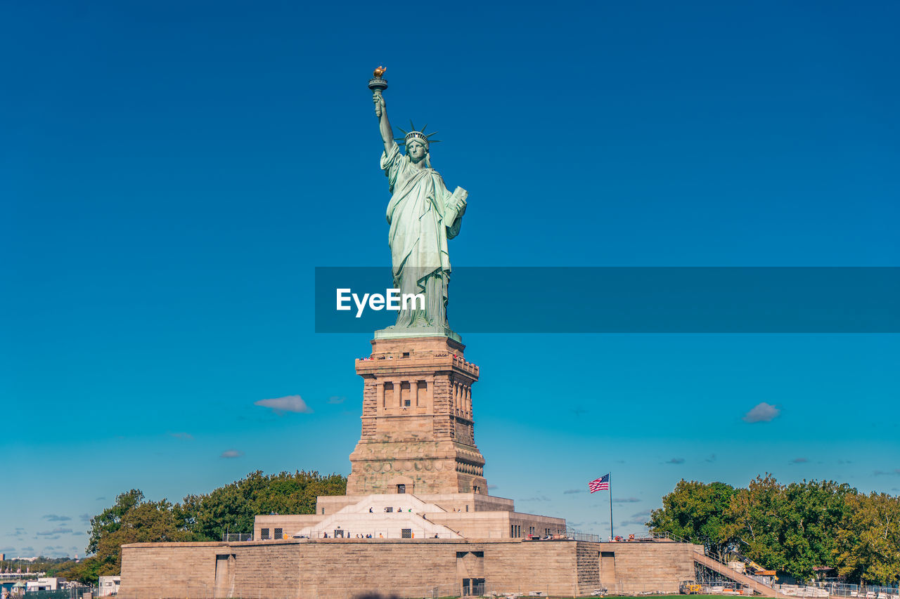 Low angle view of statue of liberty against clear blue sky