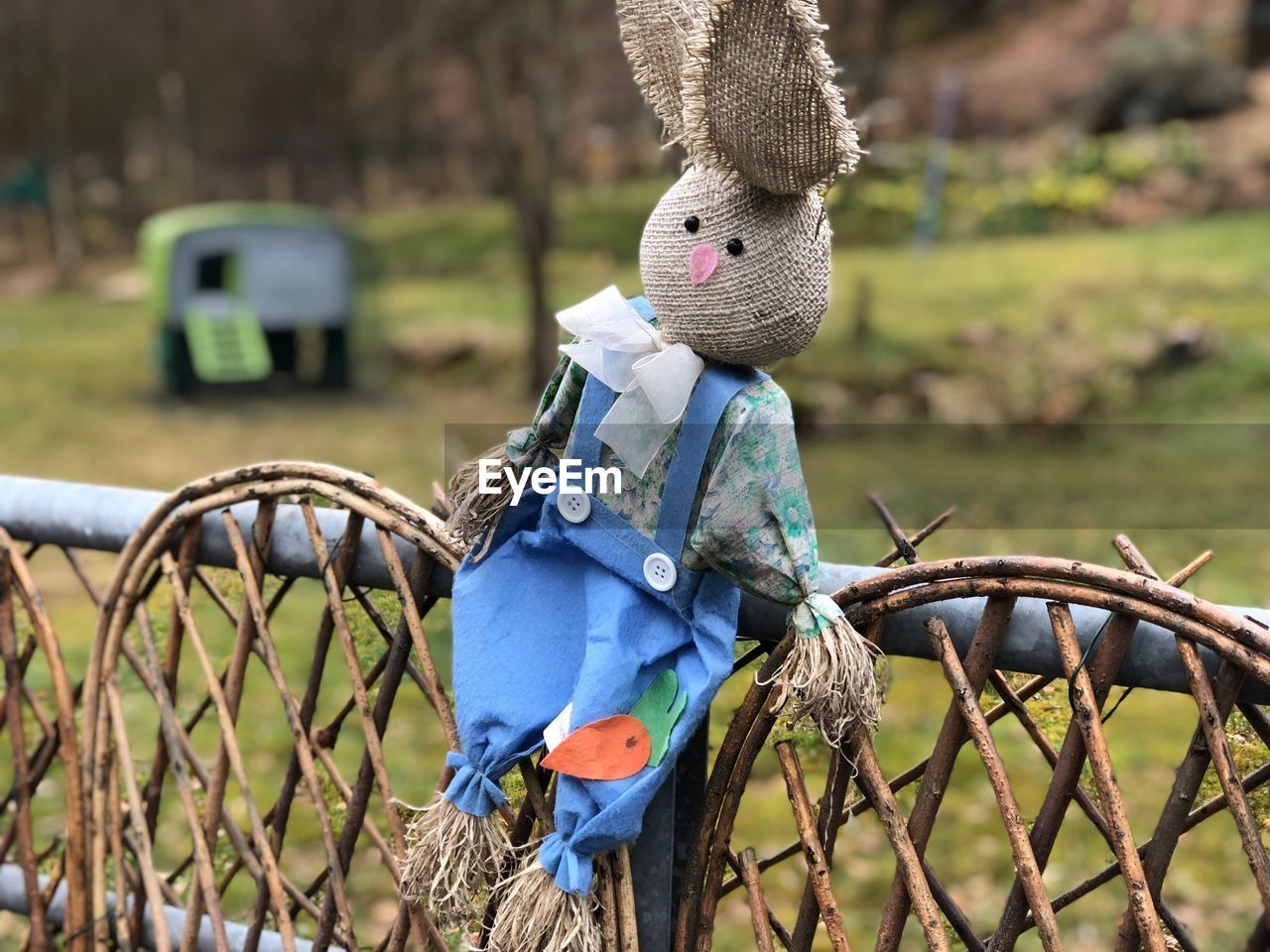 Close-up of scarecrow on fence at field