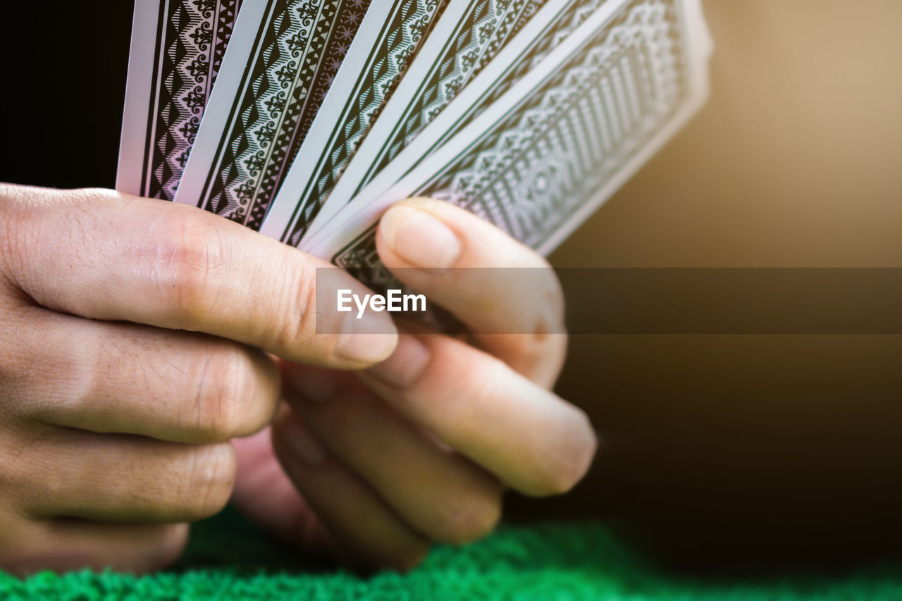 Cropped hand of person holding cards