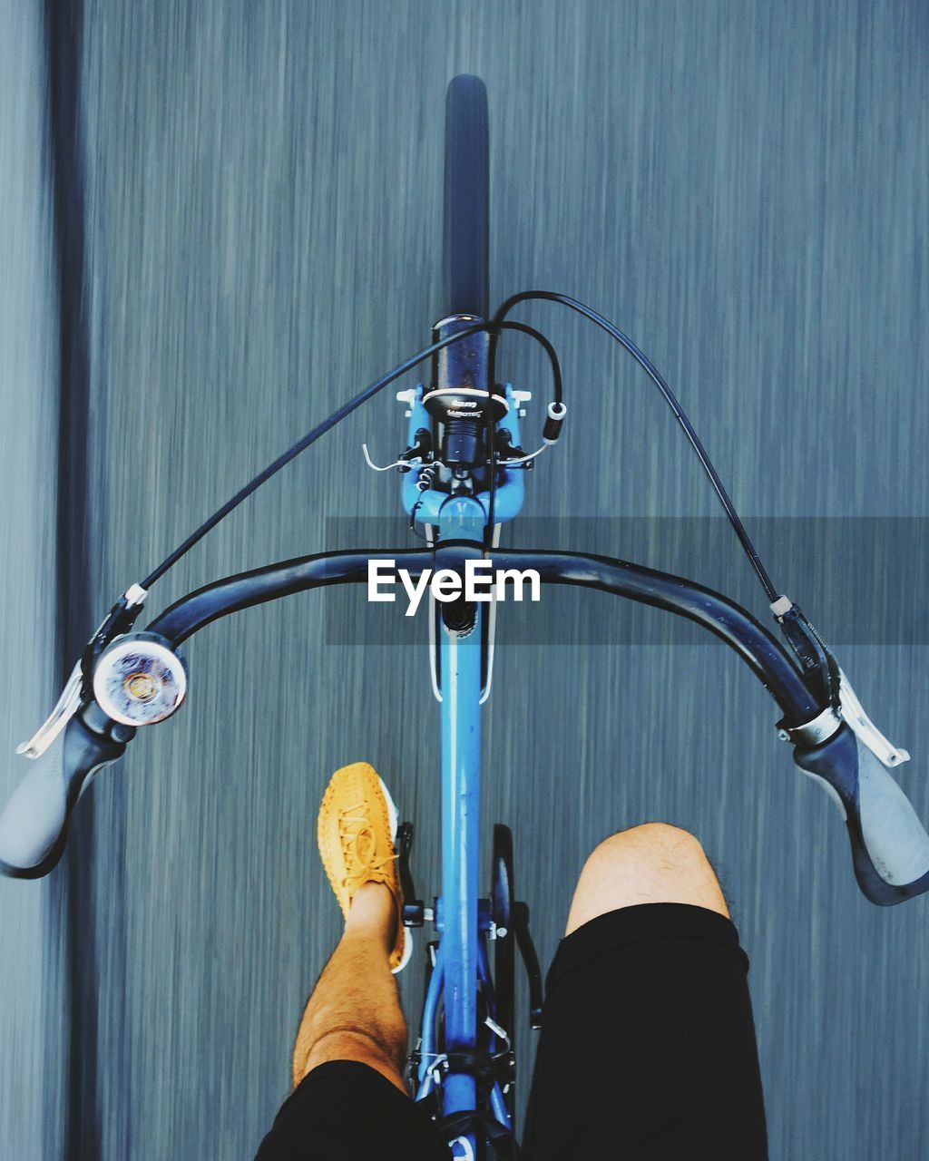 Low section of man riding bicycle on road