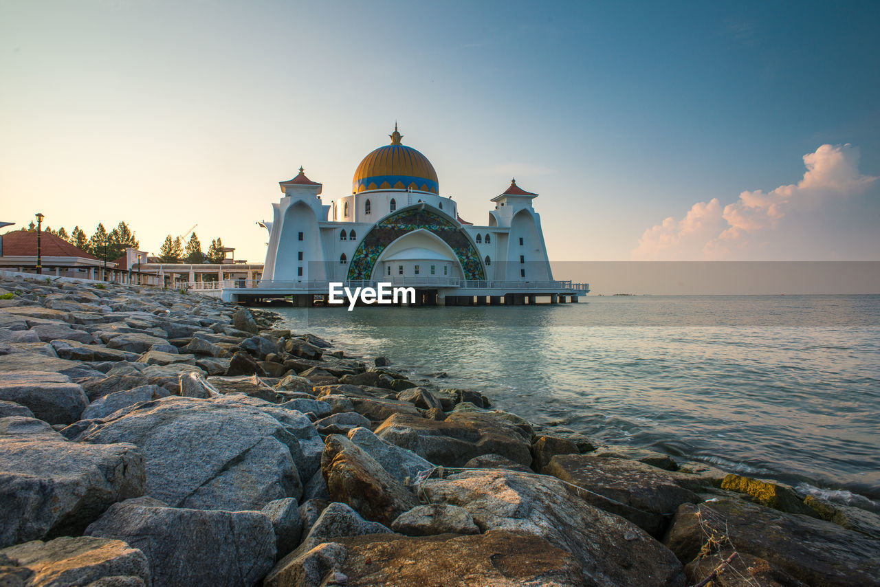 VIEW OF CHURCH AT WATERFRONT AGAINST SKY