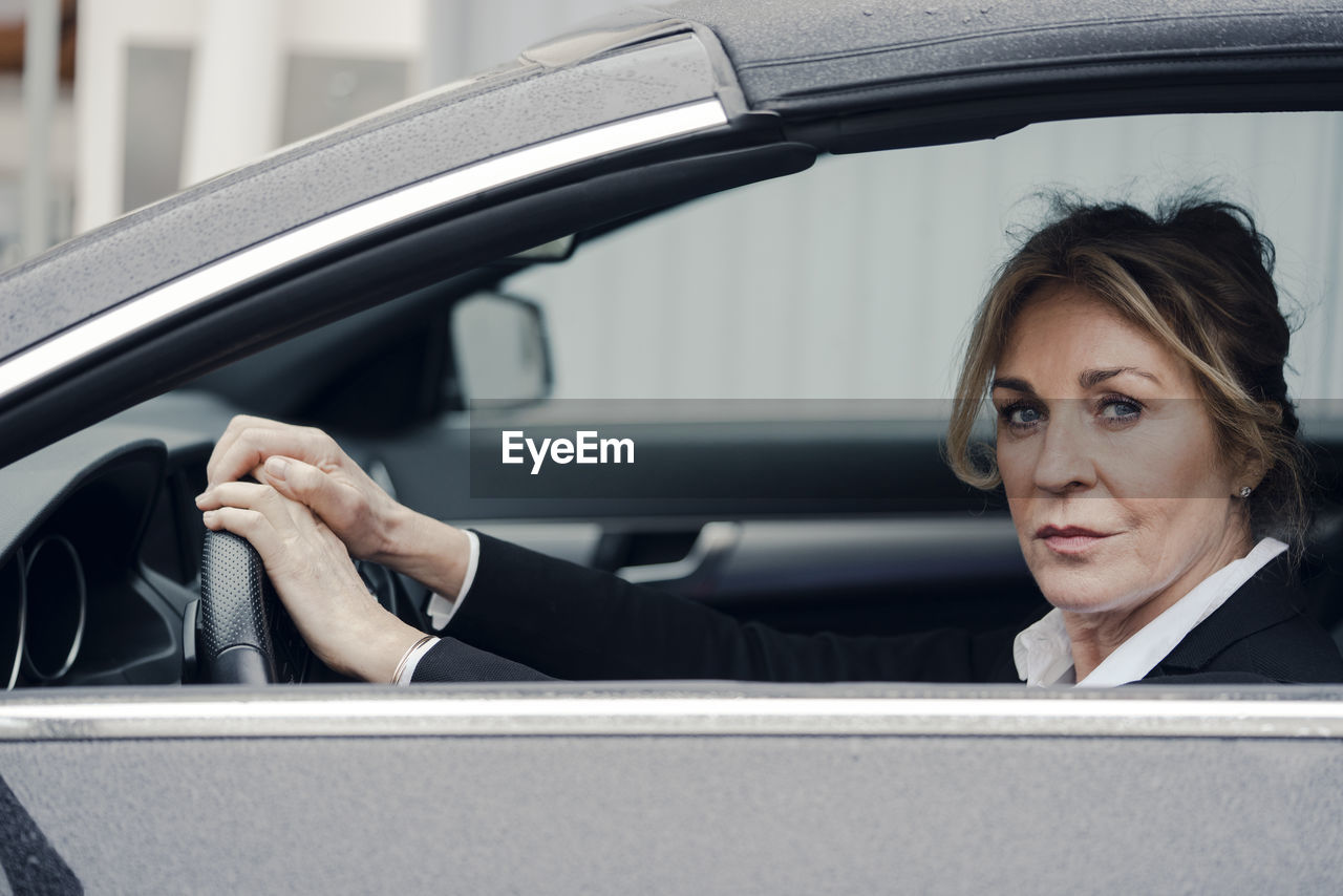 Portrait of confident senior businesswoman in car