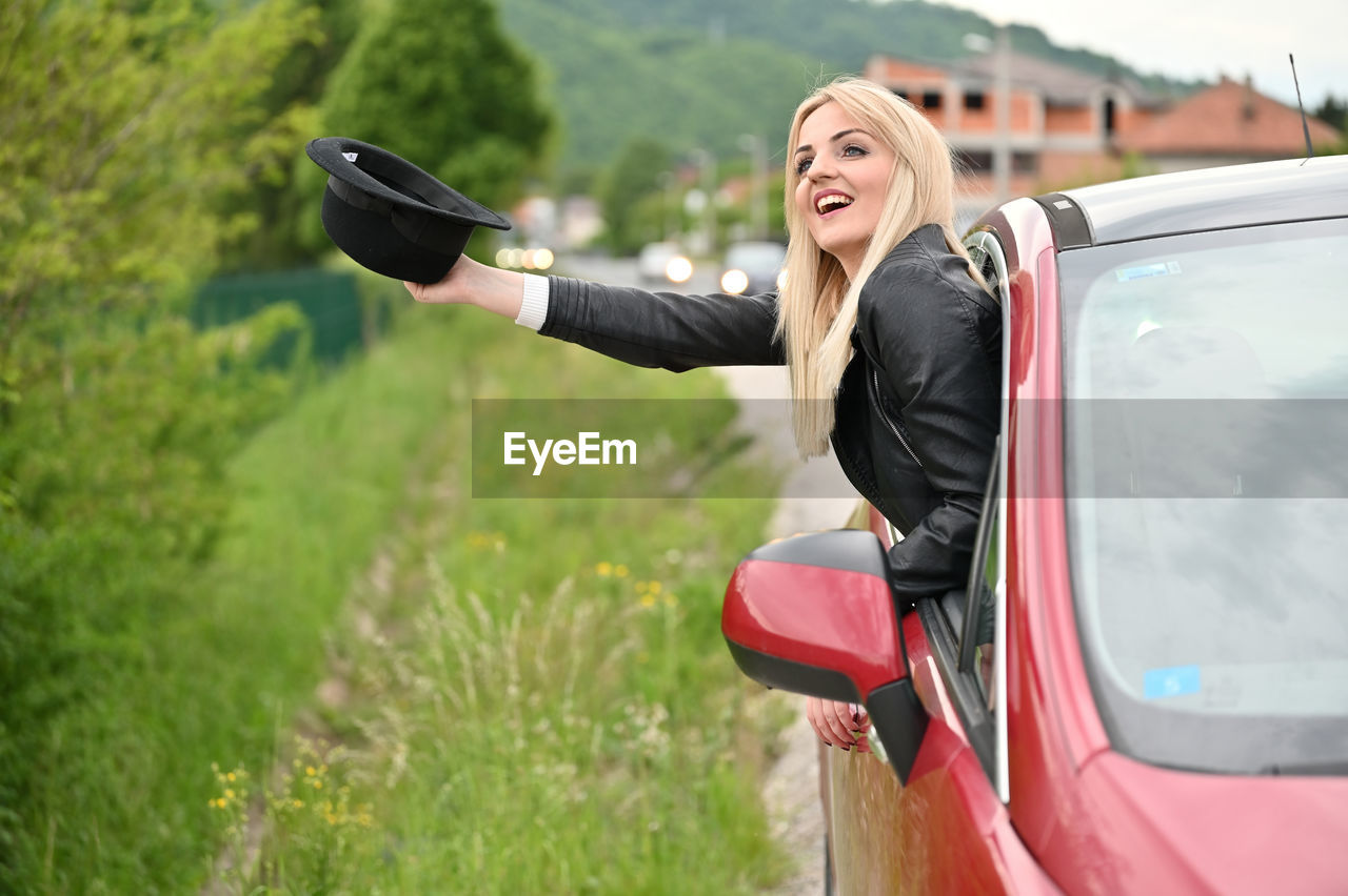 REAR VIEW OF WOMAN WITH UMBRELLA ON ROAD