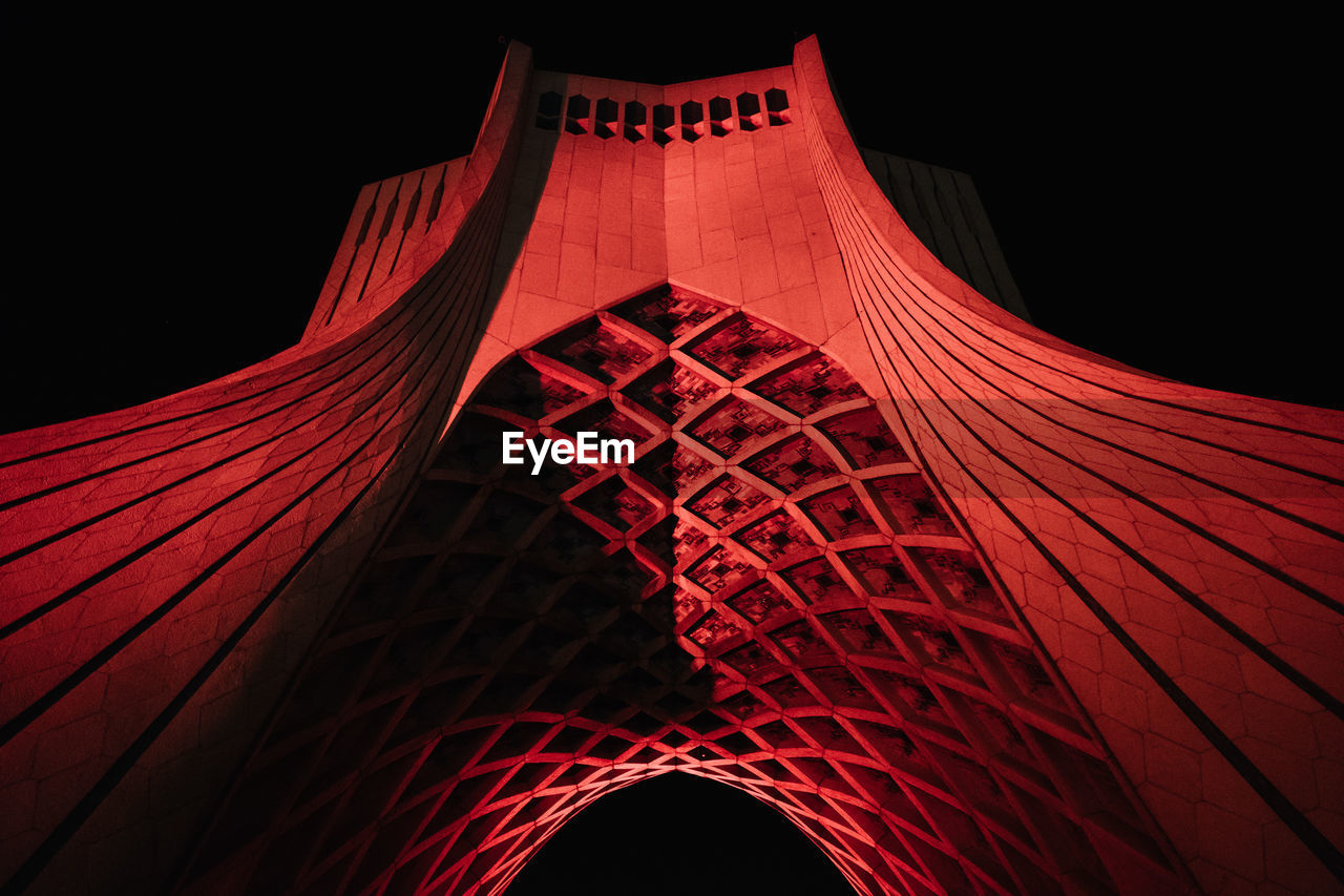 LOW ANGLE VIEW OF ILLUMINATED RED BUILDING AGAINST SKY