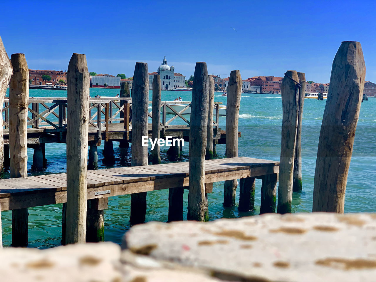 WOODEN POSTS ON PIER AGAINST SKY