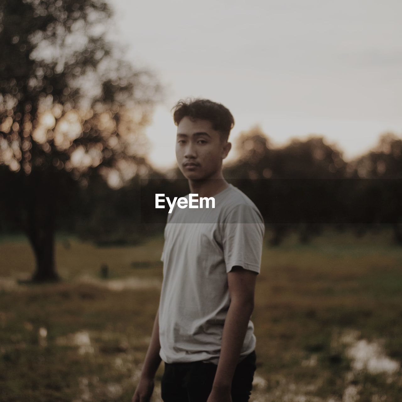 Portrait of a young man standing on field