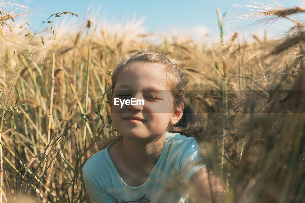 PORTRAIT OF GIRL IN FIELD