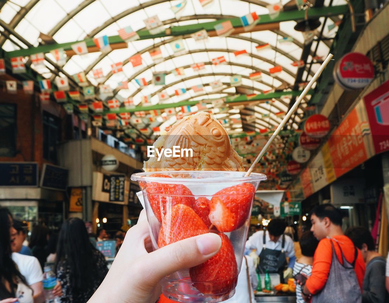 CLOSE-UP OF HAND HOLDING ICE CREAM IN CAROUSEL