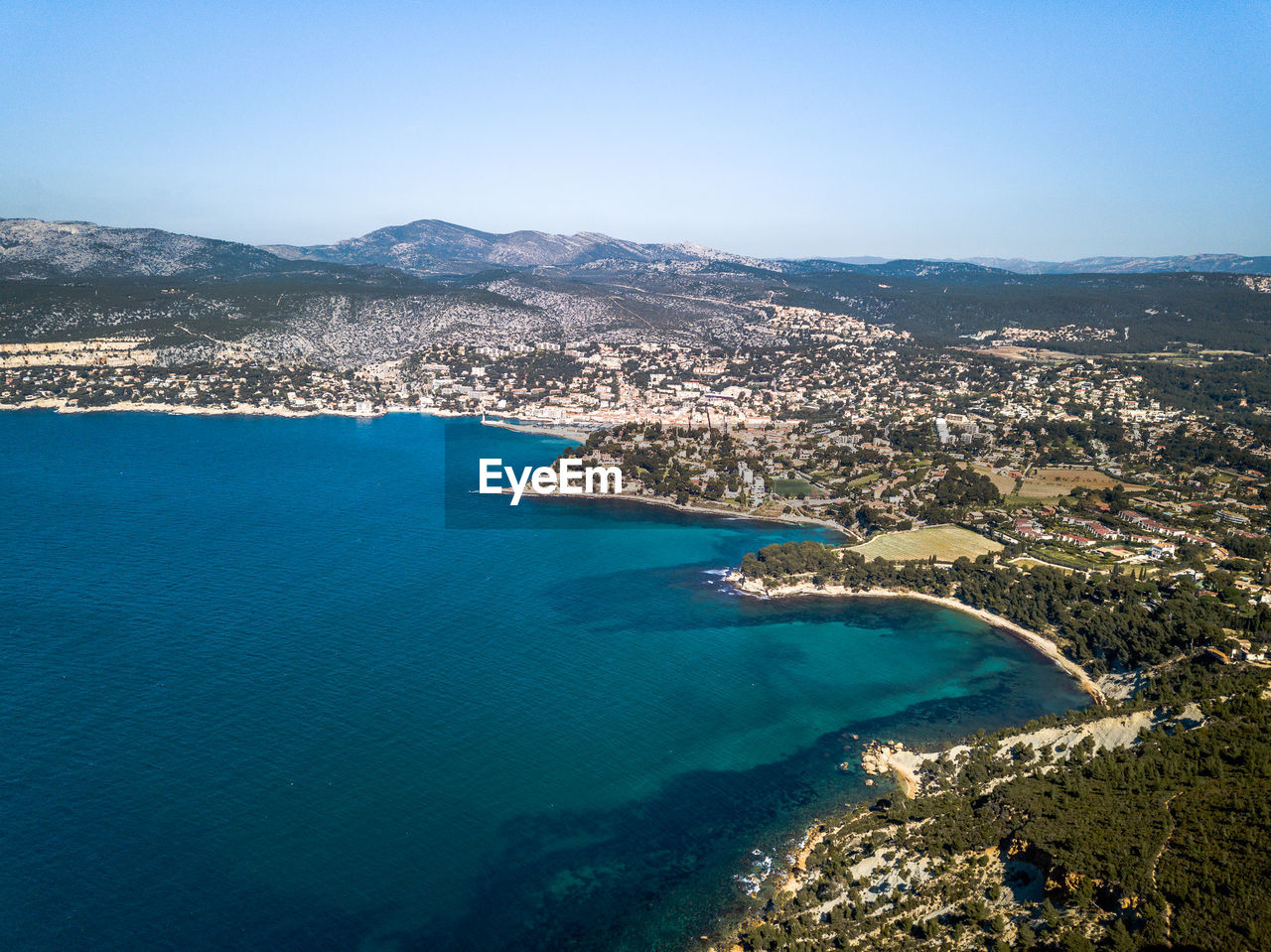 High angle view of city by sea against sky