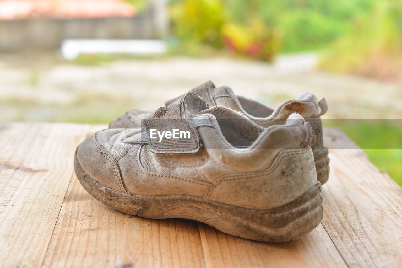 Close-up of old shoes on wooden table