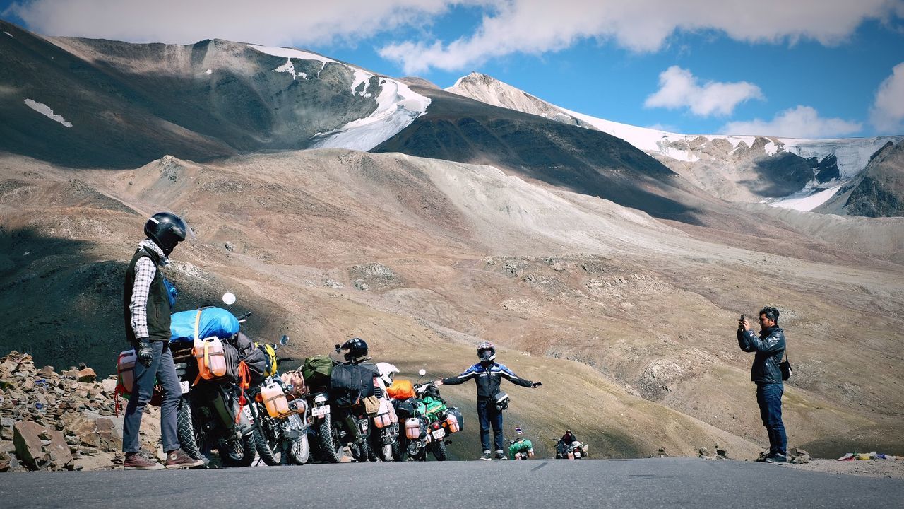 PEOPLE RIDING MOTORCYCLE ON MOUNTAIN ROAD