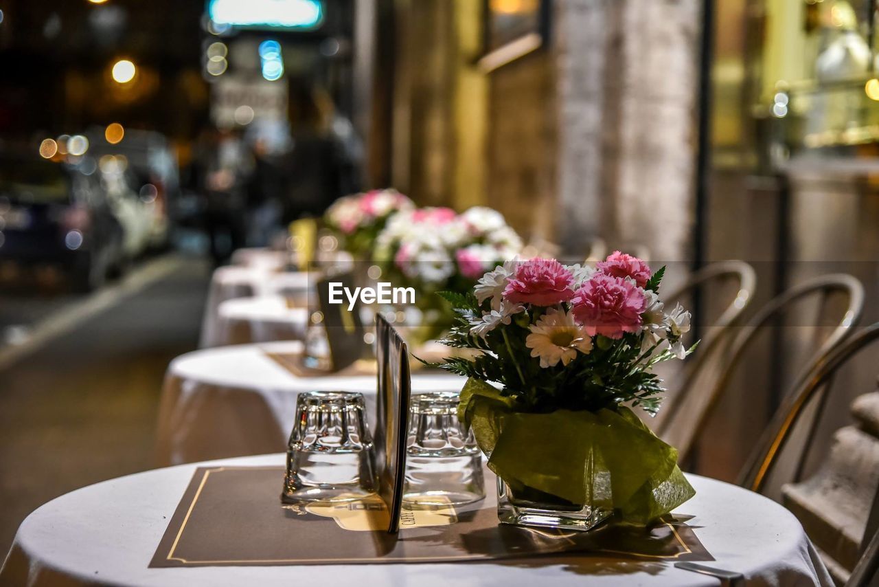 Flower pots on tables in sidewalk cafe