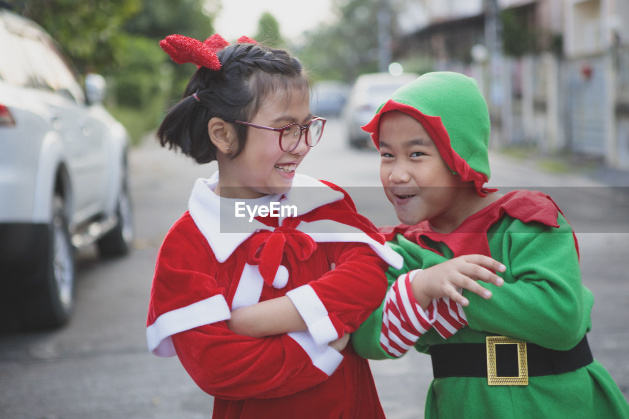 Asian girl and boy wearing santa claus suit playing with happiness outdoor