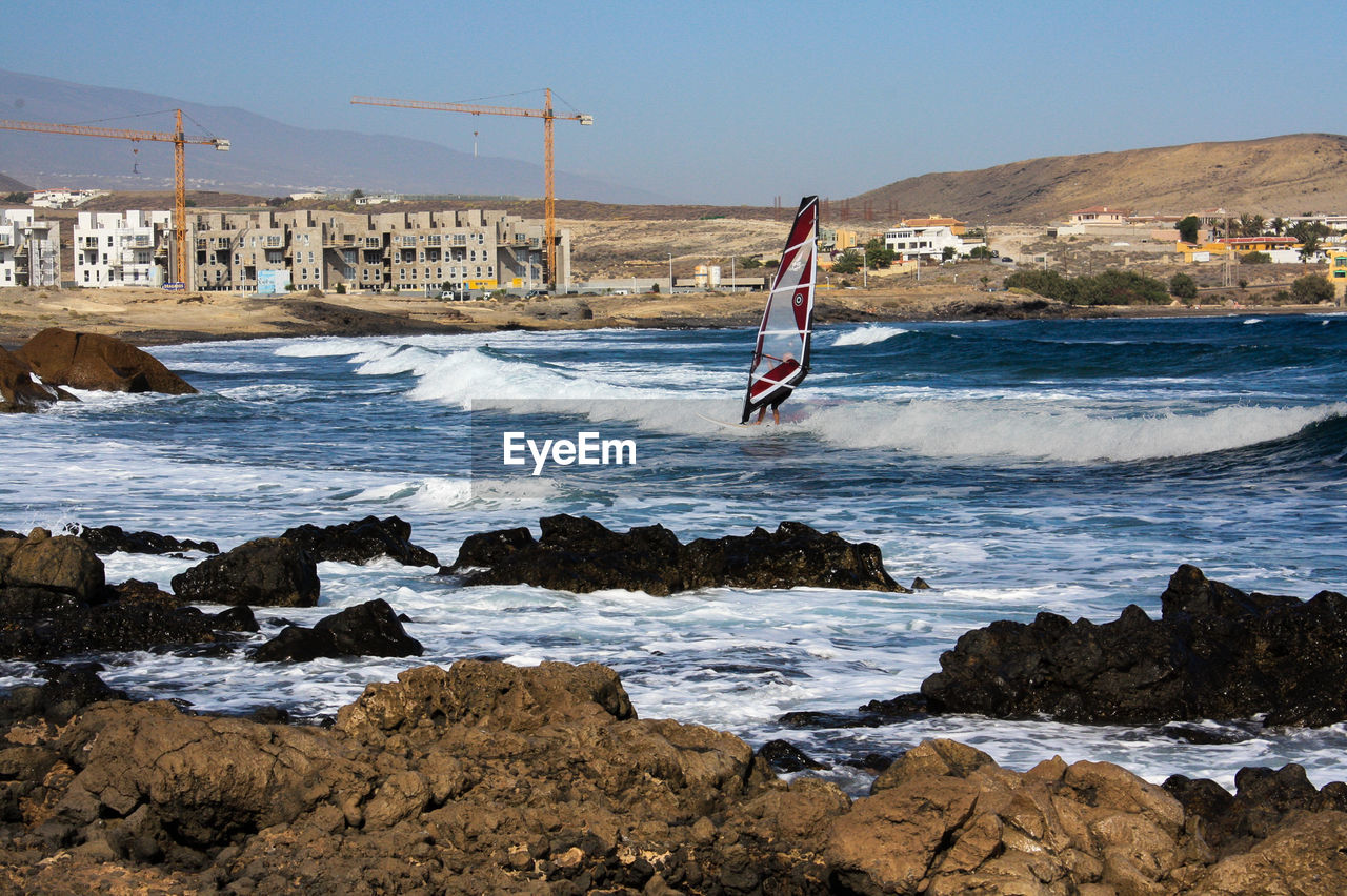 Man windsurfing in sea