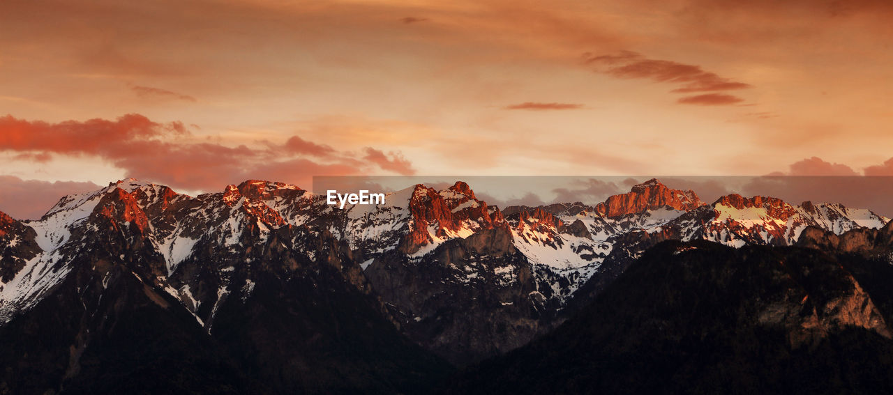 Scenic view of snowcapped mountains against sky during sunset