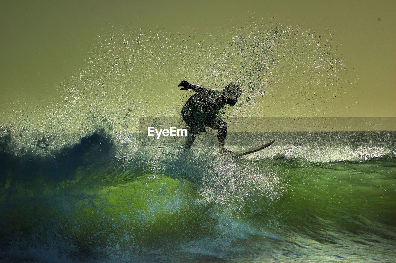 Man surfing in sea against sky