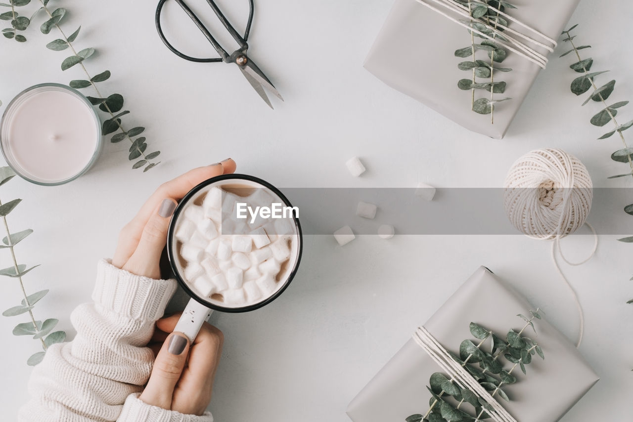 Cropped hands of woman having hot chocolate at table