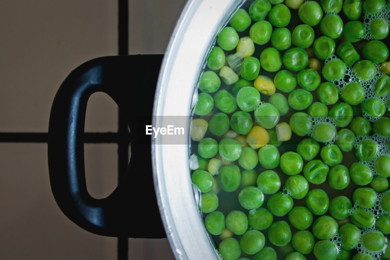 High angle view of green peas and corn boiling in cooking utensil