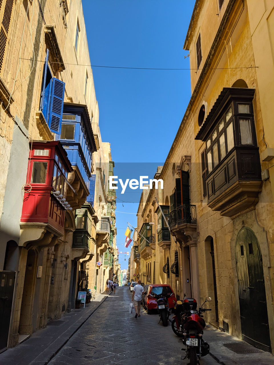 STREET AMIDST BUILDINGS AGAINST CLEAR SKY