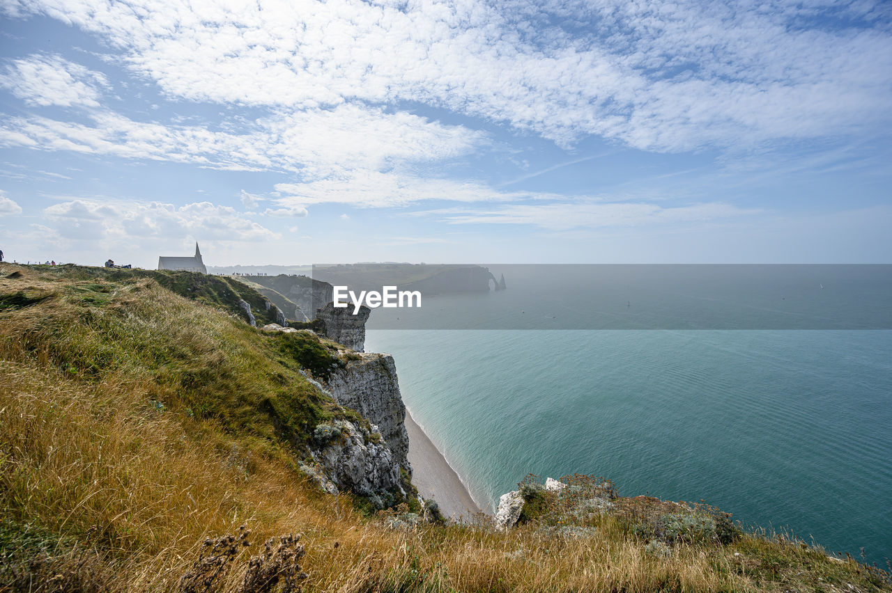 water, coast, sea, cliff, sky, scenics - nature, nature, land, cloud, beauty in nature, shore, environment, horizon, beach, terrain, ocean, body of water, travel, travel destinations, architecture, coastline, landscape, tourism, built structure, no people, mountain, tranquility, plant, outdoors, tower, bay, horizon over water, day, tranquil scene, grass, high angle view, reservoir, non-urban scene, building exterior, rock, trip, vacation, idyllic, holiday, building, blue, seascape, lighthouse, history