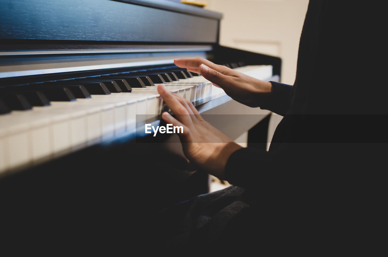 Midsection of man playing piano