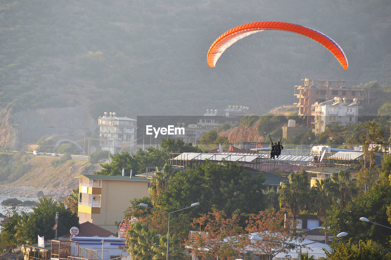 Two people in paraglider mid-air