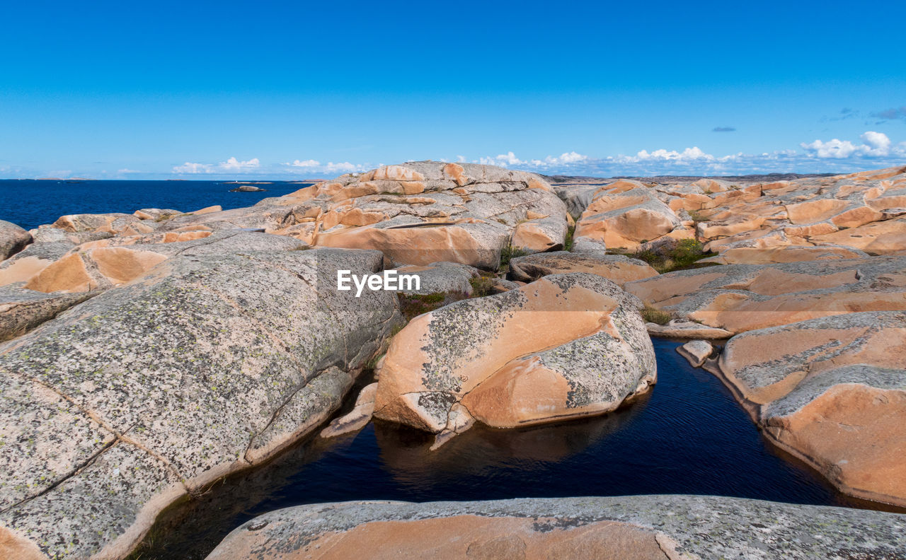 ROCKS ON SHORE AGAINST SKY