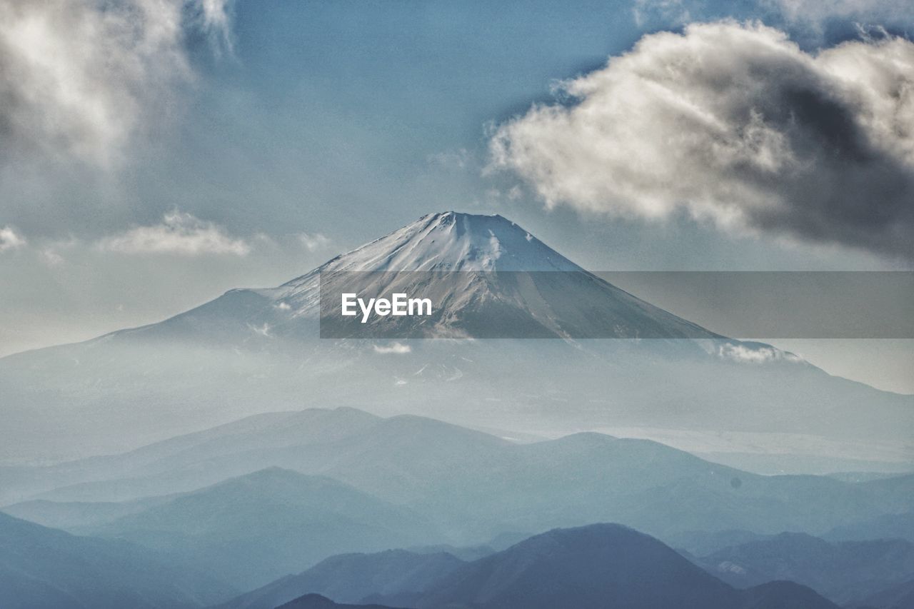 Scenic view of snowcapped mountain against cloudy sky