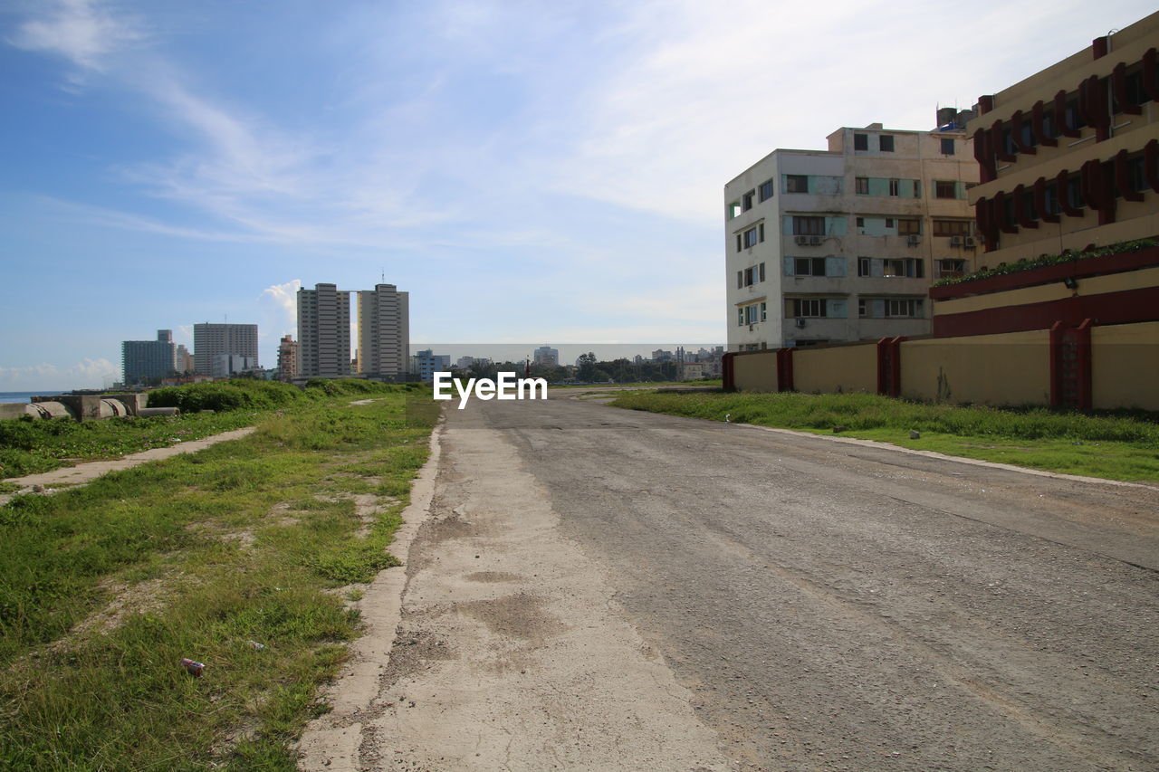 EMPTY ROAD LEADING TOWARDS CITY