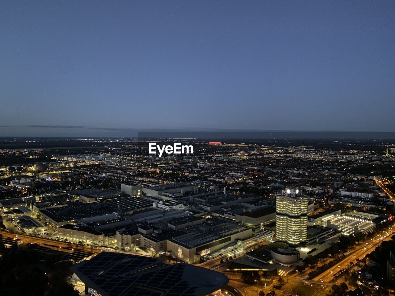 HIGH ANGLE VIEW OF ILLUMINATED BUILDINGS AGAINST CLEAR SKY