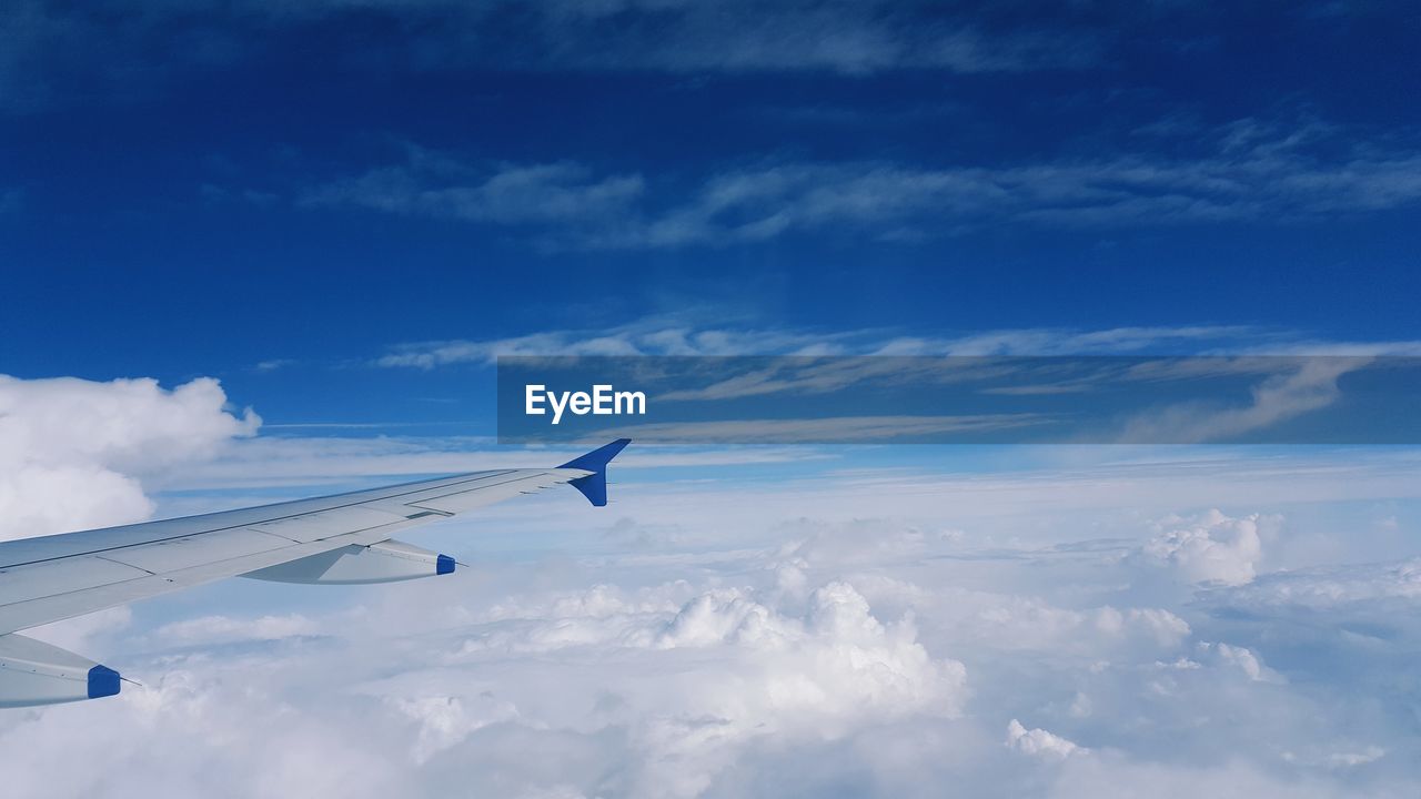 Cropped image of airplane wing flying against sky