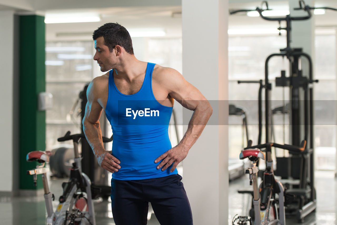 Muscular man wearing vest standing in gym