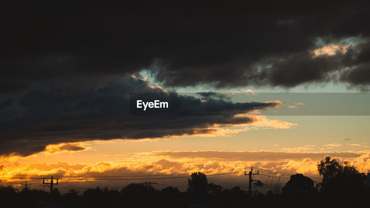 SCENIC VIEW OF SILHOUETTE TREES AGAINST DRAMATIC SKY