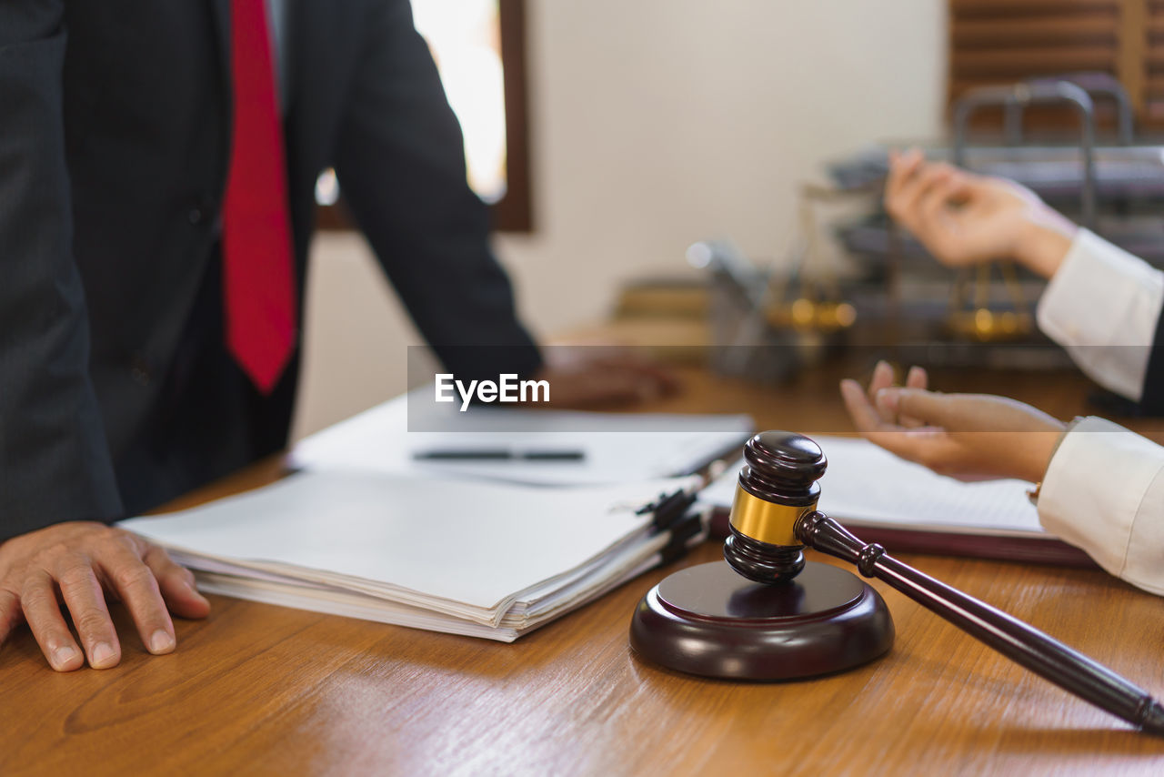 business, adult, indoors, table, men, occupation, businessman, two people, hand, office, working, focus on foreground, writing, furniture, business finance and industry, formal wear, young adult, women, holding, cooperation, midsection