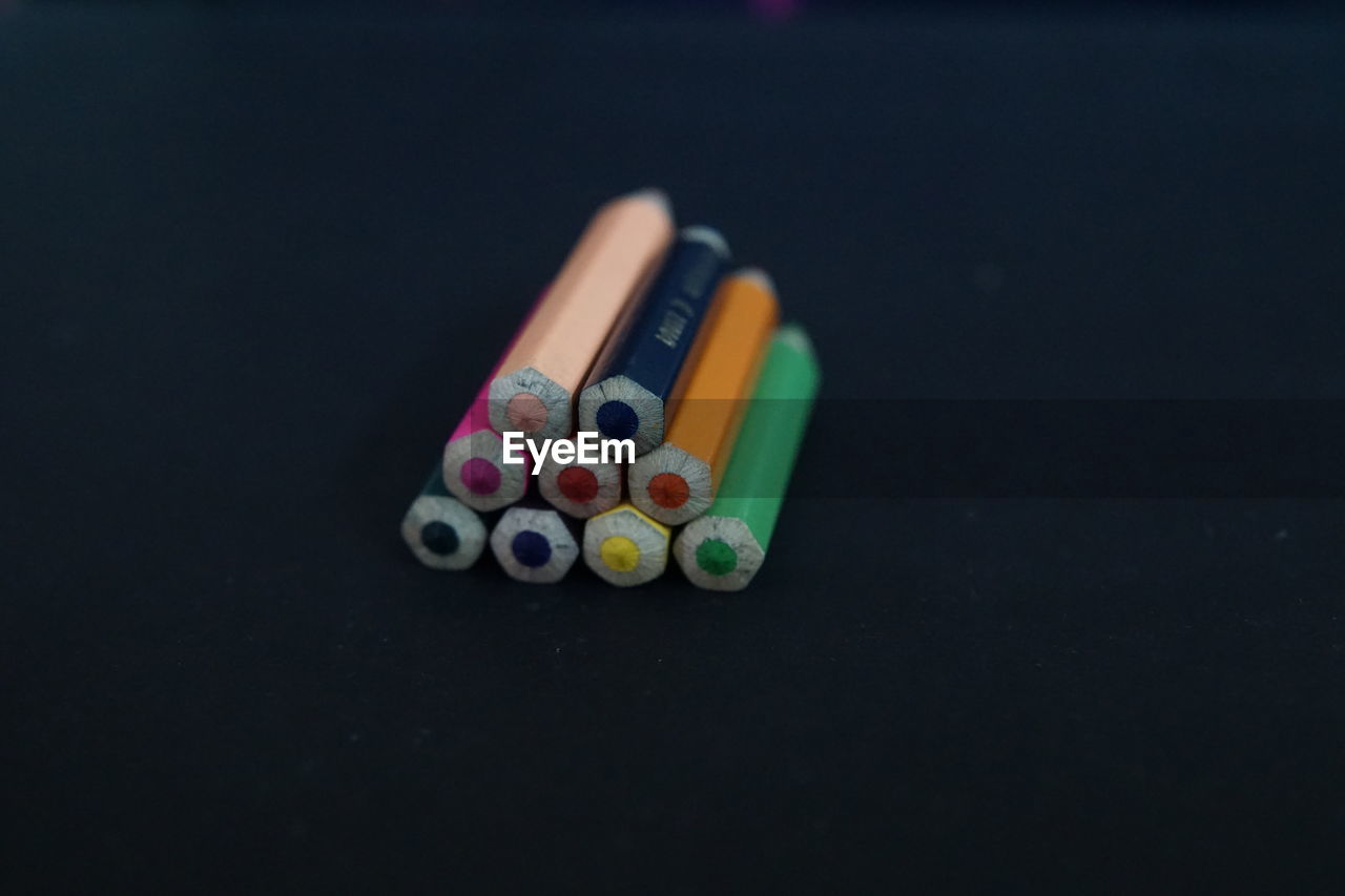 Close-up of colorful colored pencils over black background