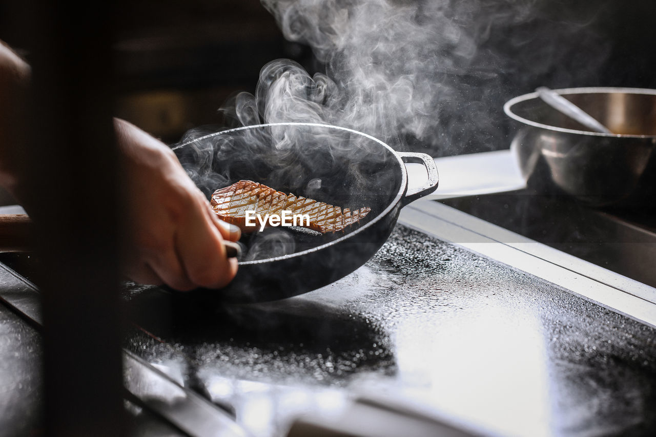 Midsection of person preparing food in kitchen