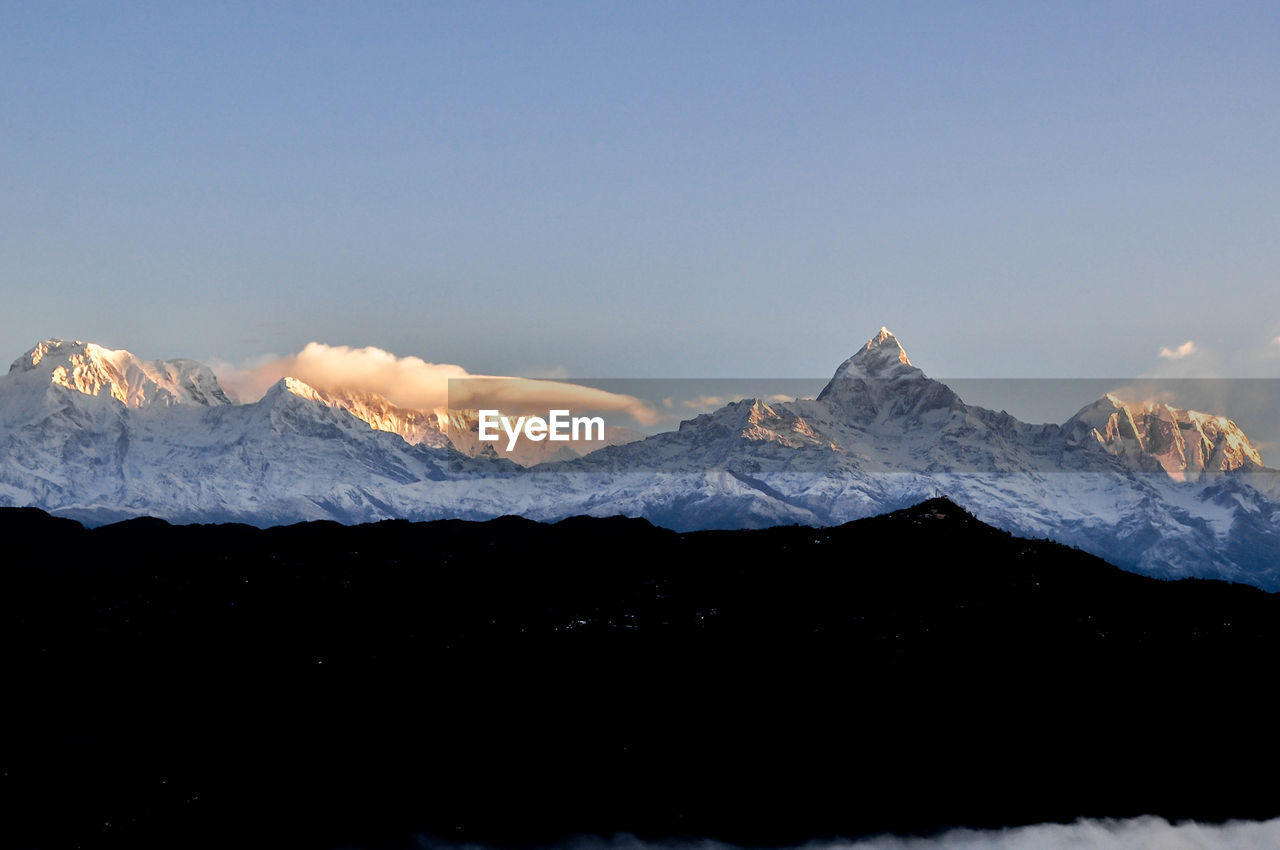 Scenic view of snowcapped mountains against clear sky