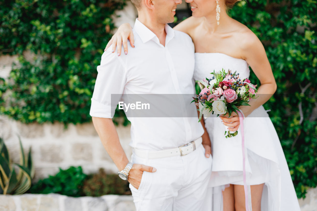 Midsection of woman holding flower bouquet