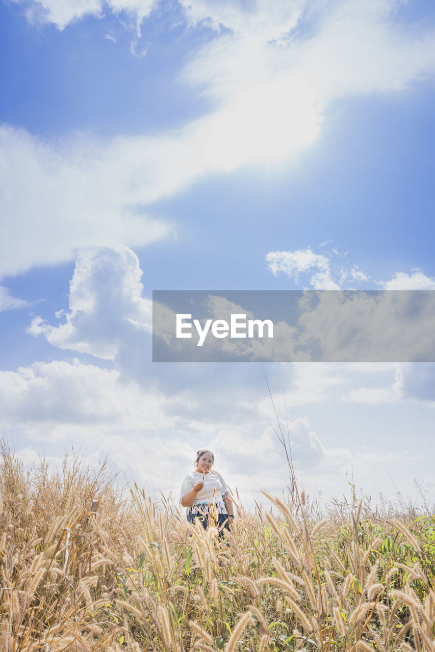 MAN SITTING ON GRASS IN FIELD